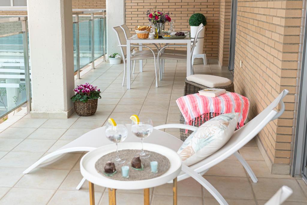 un patio con sillas y una mesa con gafas. en Arrecife 3 dormitorios, en Peñíscola