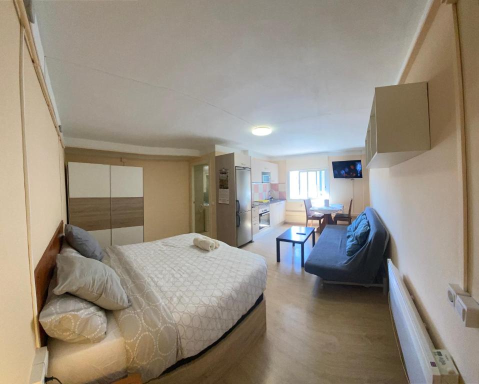 a small bedroom with a bed and a kitchen at Hostel Penedes in Vilafranca del Penedès