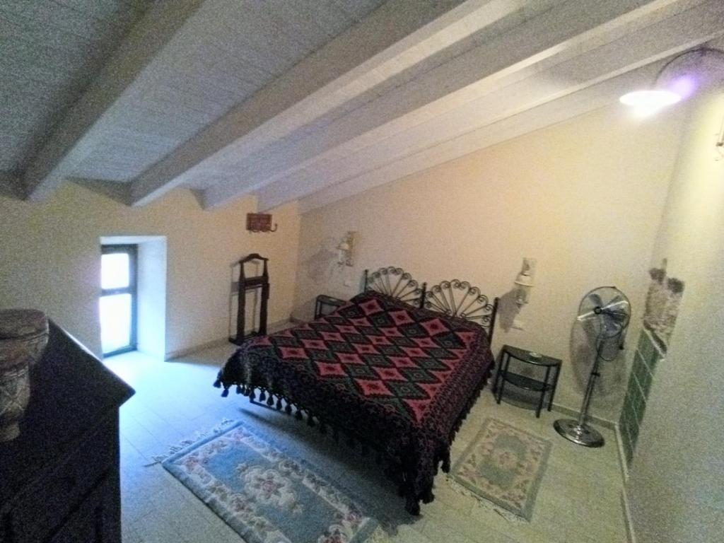 1 dormitorio con 1 cama y ventilador en Chris Home, en Pastena