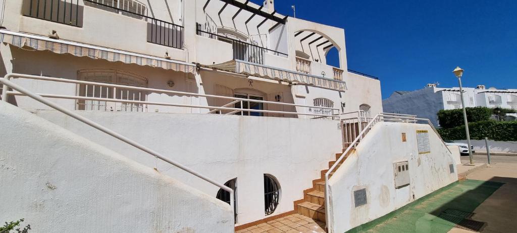 een groot wit gebouw met een trap ervoor bij MOJACAR PLAYA ADOSADO con piscina in La Marina de la Torre