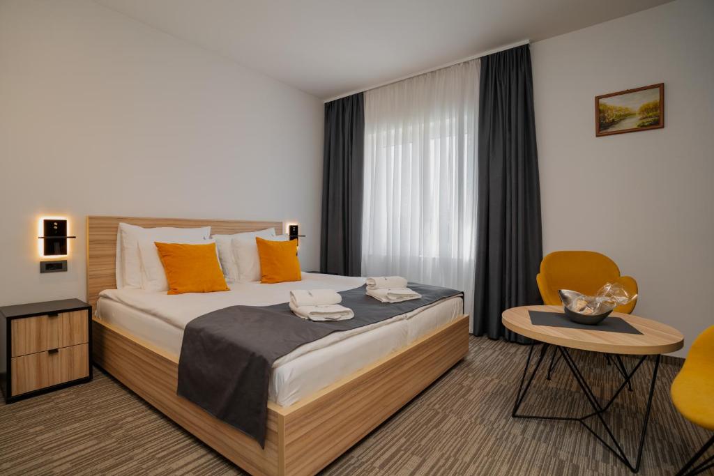 1 dormitorio con 1 cama, 1 mesa y 1 silla en Maestro - Rooms & Resturant, en Vukovar