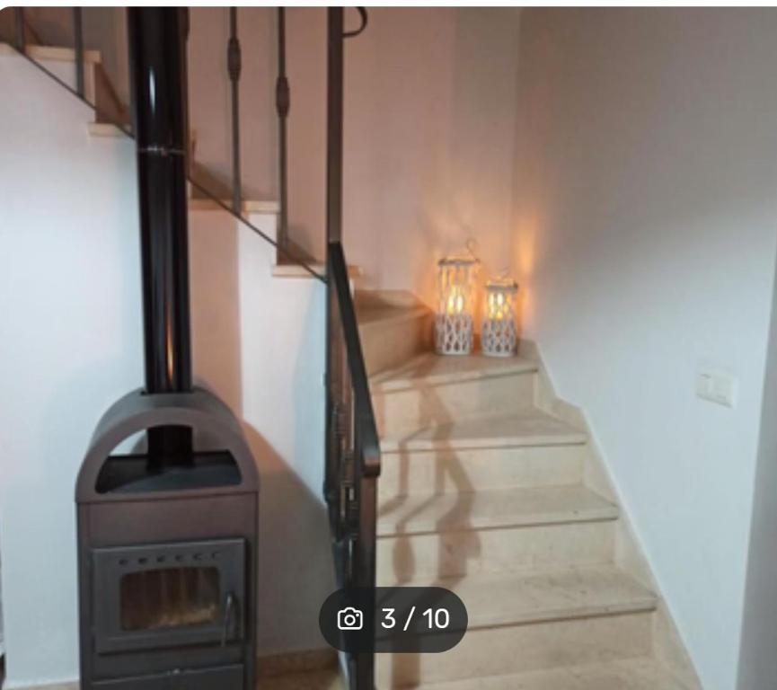 a wood stove in a room with some stairs at CASA ENROCADA in Setenil