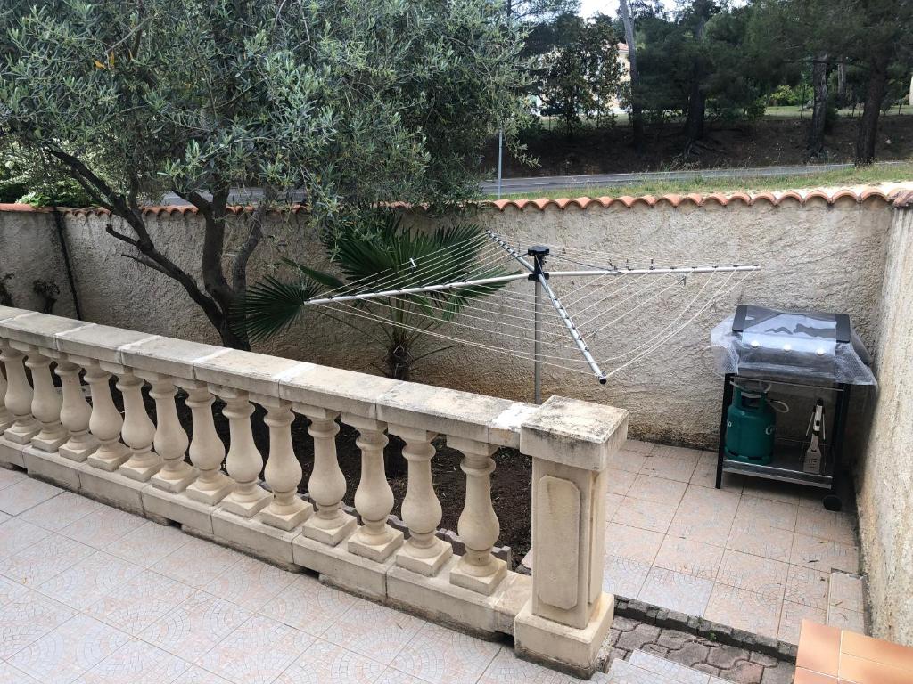 a fence with a net and a trash can at Maison la Londe in La Londe-les-Maures