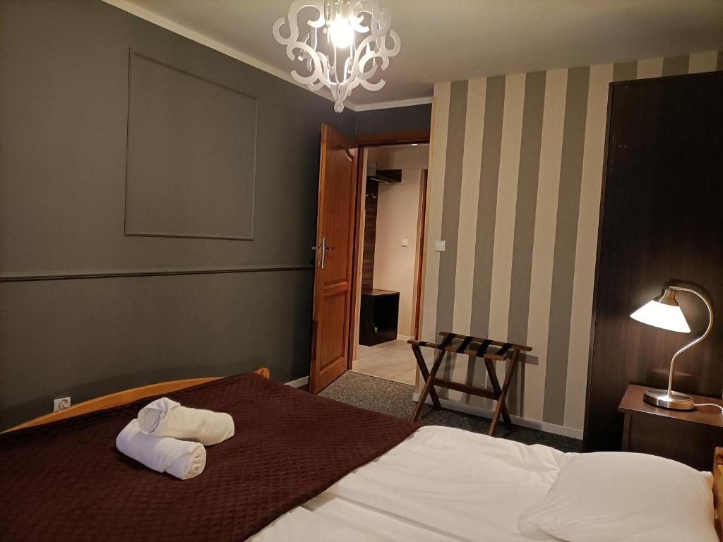ザコパネにあるWilla na Wilcznikのベッドとシャンデリアが備わるホテルルームです。