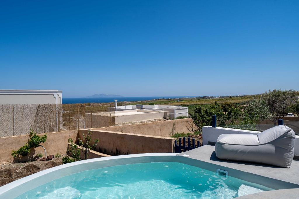 a hot tub on a patio with a view of the ocean at Amera Suites in Fira