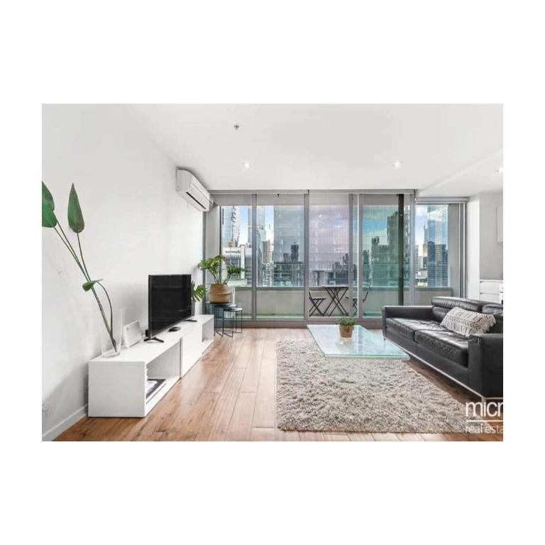 a living room with a couch and a television at Lovely apartment in Melbourne