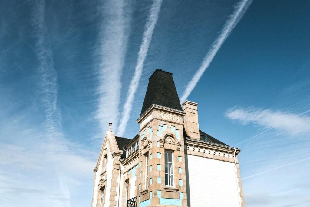 une tour d'un bâtiment avec un ciel dans l'établissement La Brise, à Roscoff