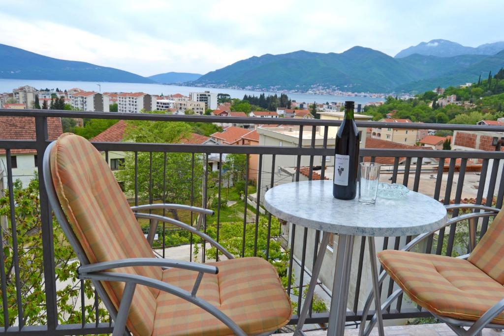 uma garrafa de vinho sentada numa mesa na varanda em Tivat Apartments em Tivat