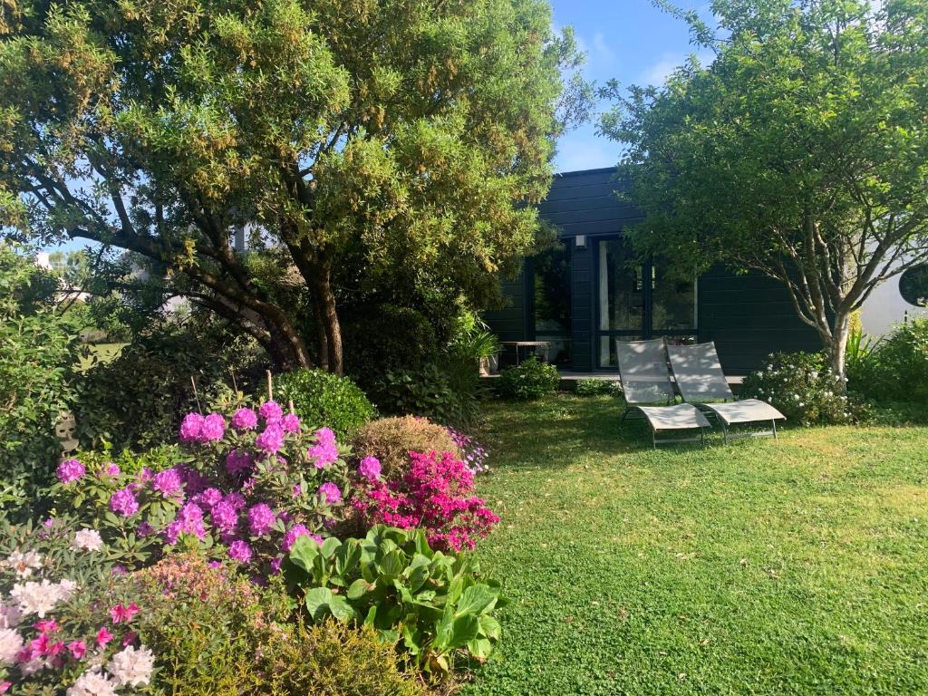 um jardim com flores e um banco em frente a uma casa em Ker Mouettes em Arradon