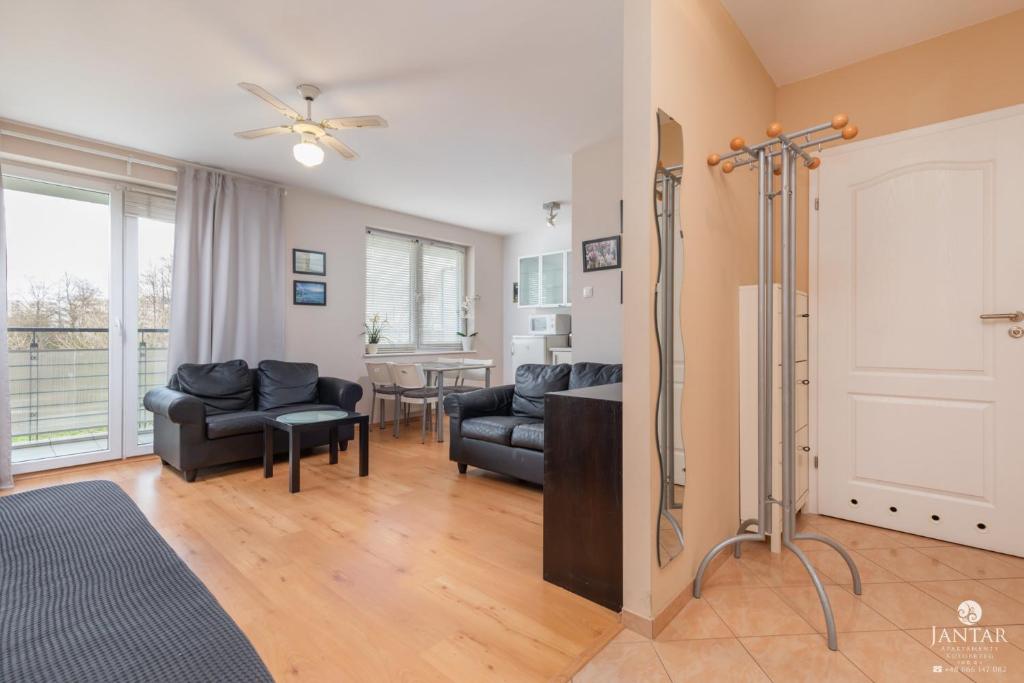 uma sala de estar com um sofá e uma mesa em Jantar Apartamenty- Zielone Tarasy em Colberga
