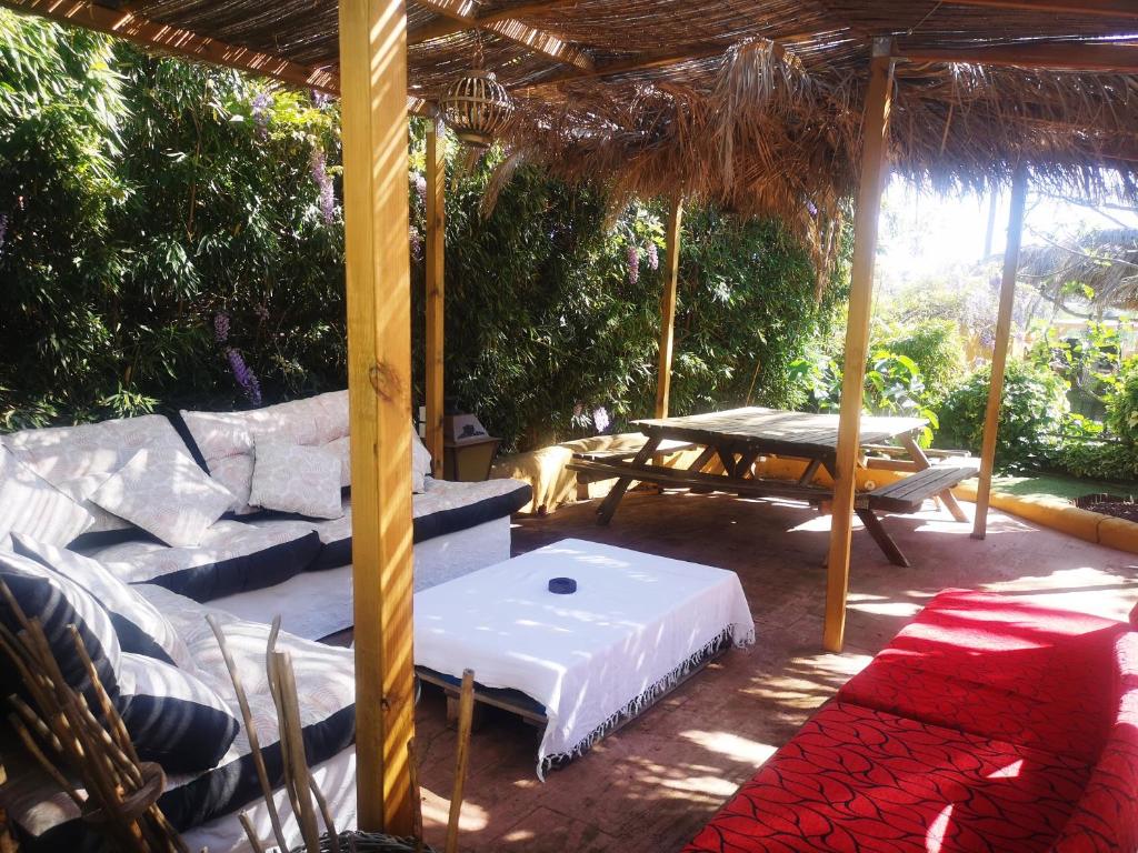 un patio con sofá, mesa y alfombra en Viviendas Uso Turisitico, Al BUHAR, en Torrejón del Rey
