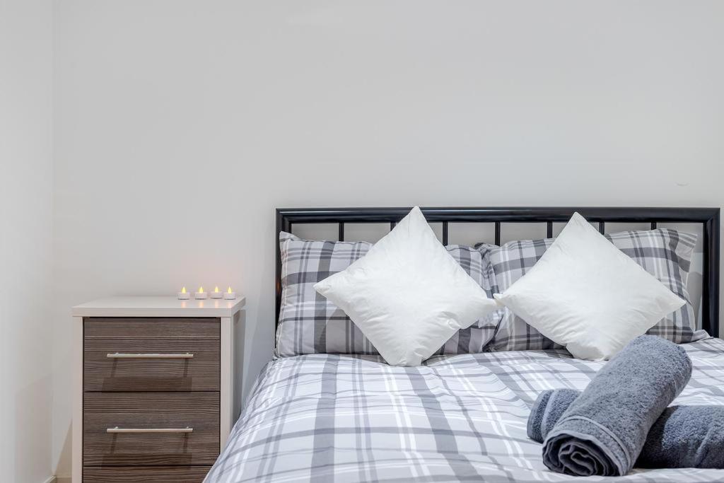 een slaapkamer met een bed met witte en blauwe kussens bij City Sparrow Nest -12W in Londen