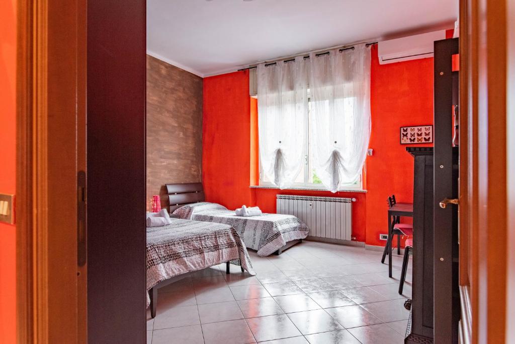 a red room with two beds and a window at Casa Metro Lingotto in Turin