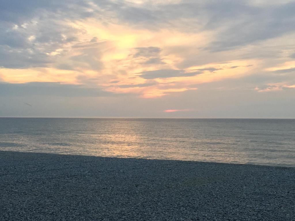 een strand met een bewolkte hemel en de oceaan bij Studio à 20m de la mer in Mers-les-Bains