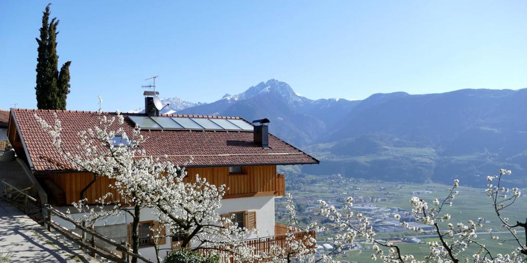 a house with a view of a valley and mountains at Der Luemerhof in Marlengo