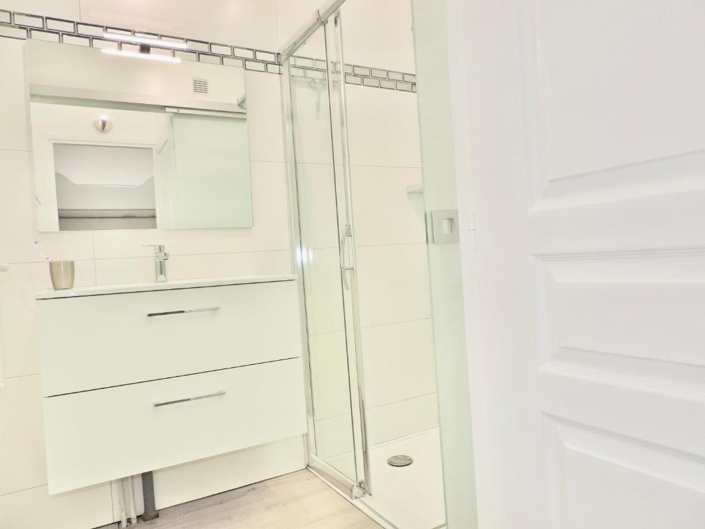 a bathroom with white cabinets and a glass shower at Gîte 3*** Le Chardon Bleu in Saint-Lary-Soulan