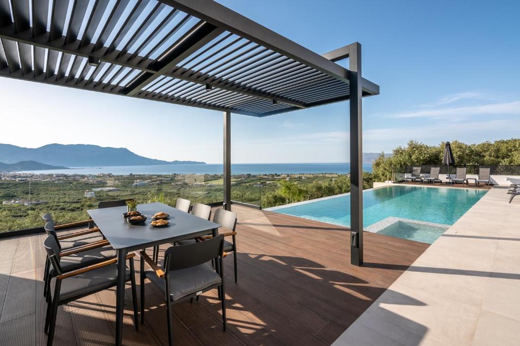 a patio with a table and chairs and a swimming pool at Villas Phos and Kallos in Kissamos