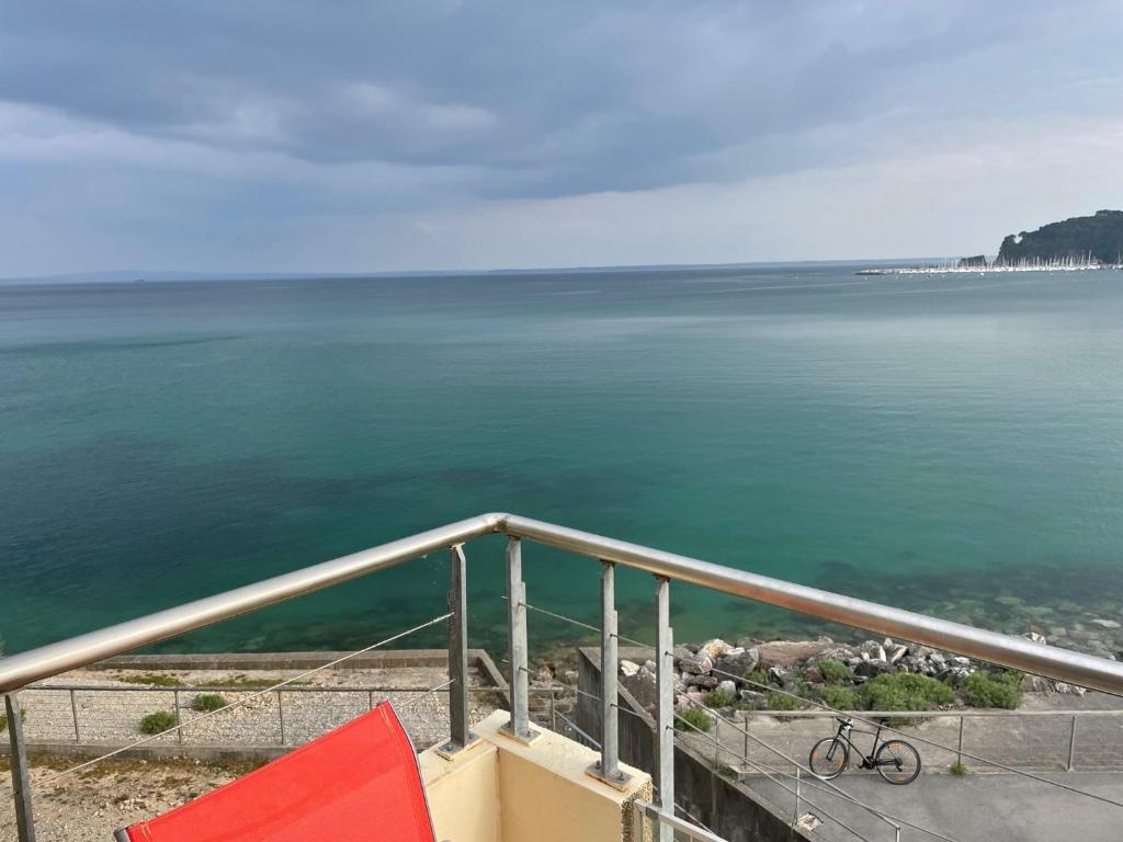 una bicicleta sentada en una barandilla cerca del agua en Appartement cosy les pieds dans l’eau, vue mer exceptionnelle, en Crozon