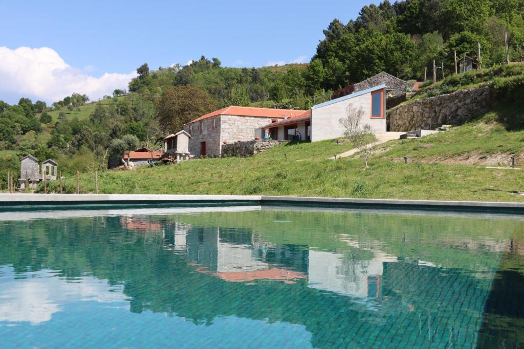 a pool of water in front of a house at Quinta da Riba Má in Santa Leocádia