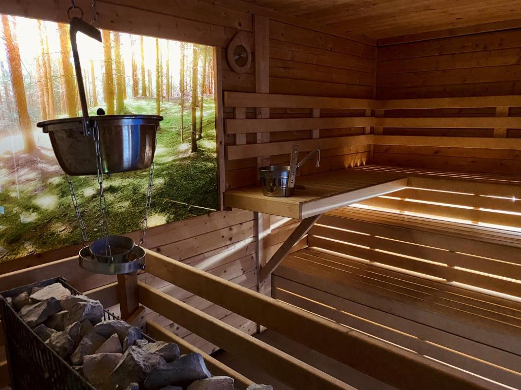 a wooden sauna with a bucket on the wall at Hotel garni Kleindienst in Ursensollen