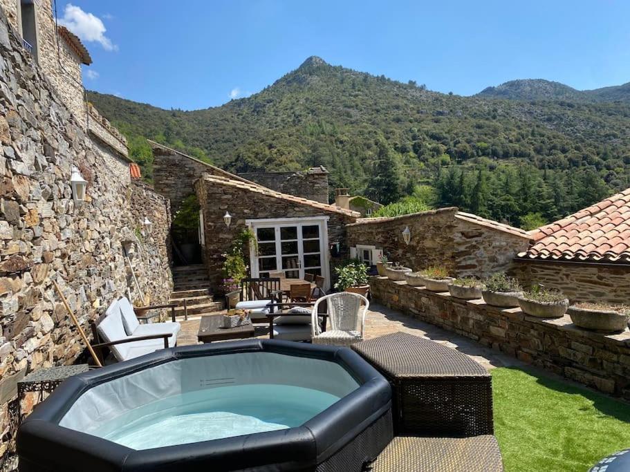 a house with a hot tub in a yard at Les Terrasses in Cabrespine