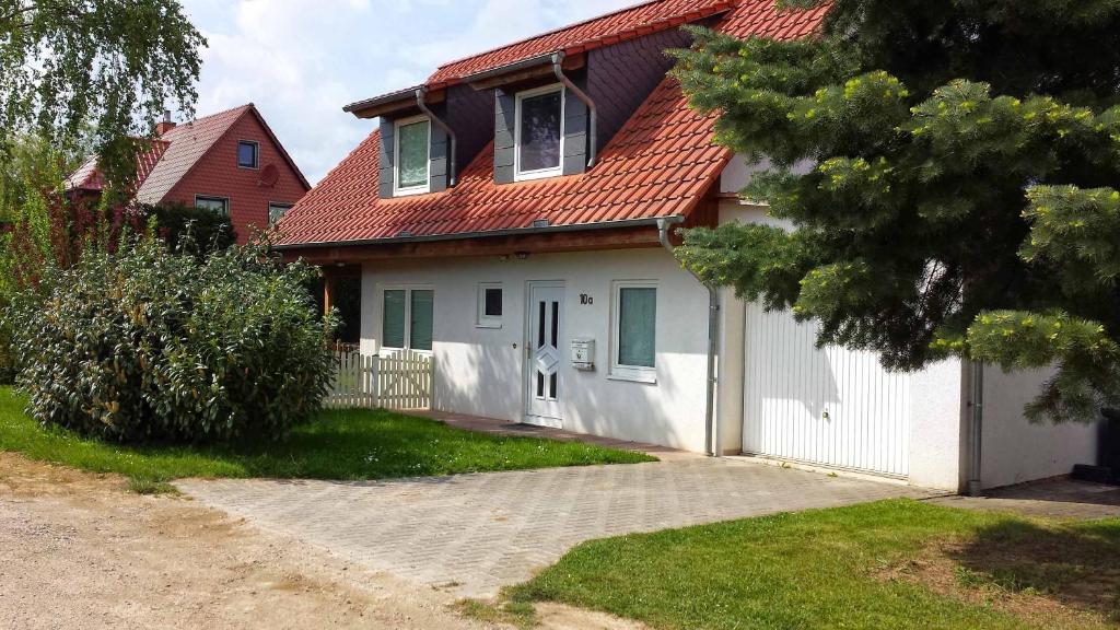 uma casa branca com um telhado vermelho e uma entrada em Haus Weitblick em Einbeck