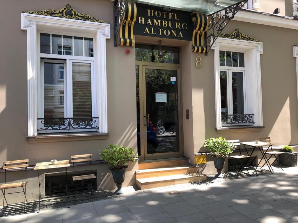 a hotel entrance with tables and chairs in front of a building at Merite Hotels Hamburg Altona GmbH in Hamburg