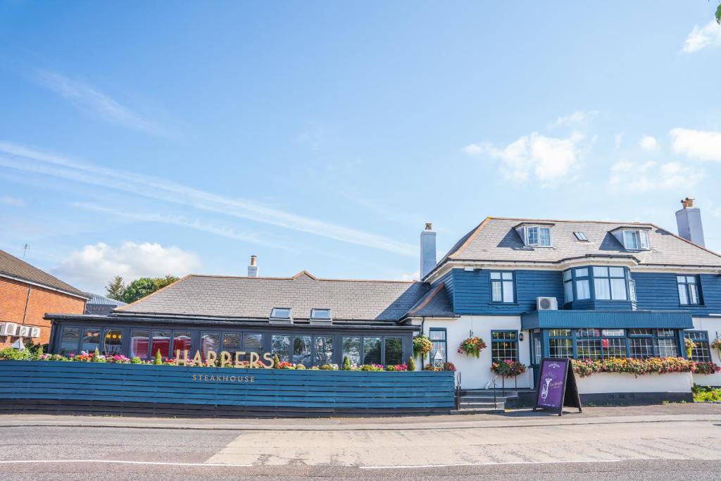 a blue building with a restaurant in front of it at Harper's Steakhouse with Rooms, Southampton Swanwick Marina in Lower Swanwick