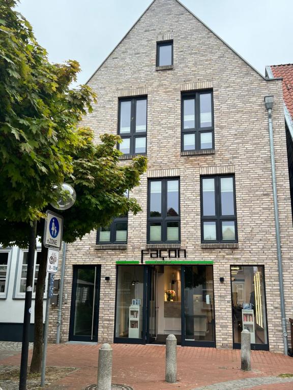 - un grand bâtiment en briques avec des fenêtres donnant sur une rue dans l'établissement Wohnung bei Façon, à Eckernförde