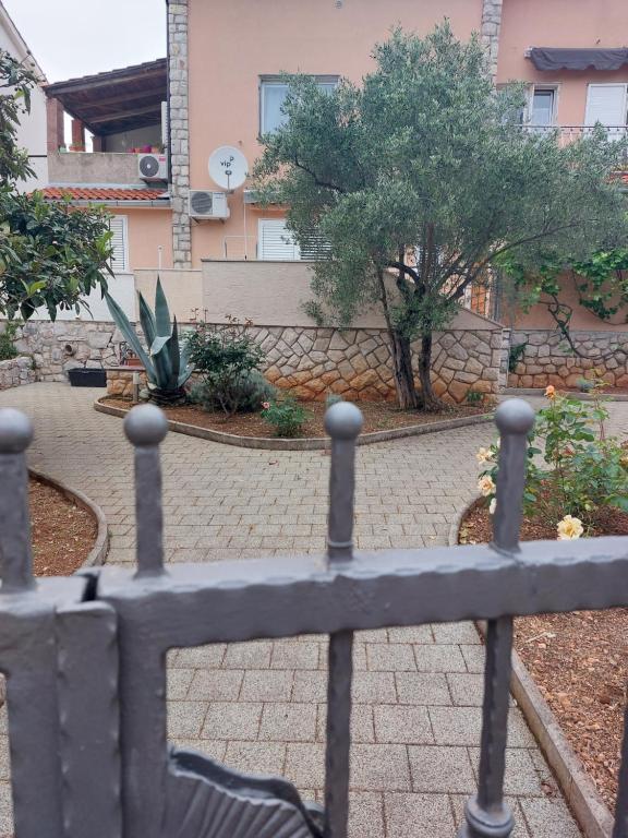 a fence with a bench in a courtyard at APARTMAN VERA in Cres