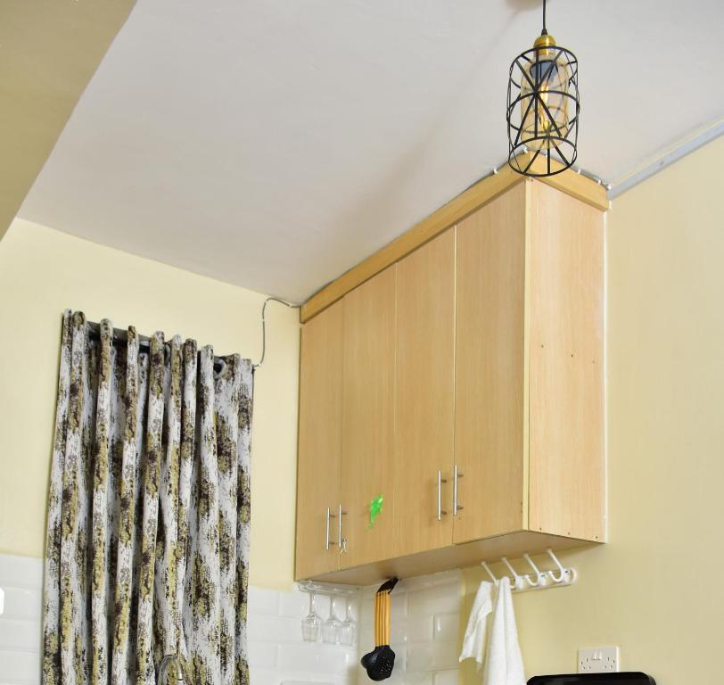 a cupboard in a kitchen with a curtain at Ruby Modern Homes Studio Apt-Imara Daima Behind Imaara Mall-JKIA-Nebula in Nairobi