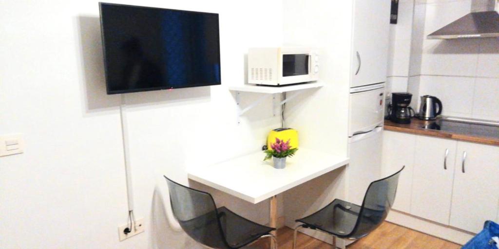 Il comprend une cuisine avec 2 chaises et une table avec une télévision. dans l'établissement Ideal estudio en el centro con WIFI, à Ronda