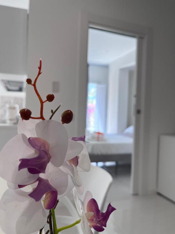 un vase rempli de fleurs violettes et blanches dans une pièce dans l'établissement Aretusa Resort Amalfi Coast, à Vietri