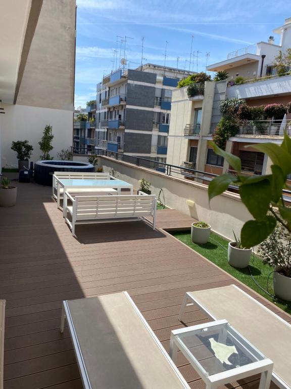 un balcón con 2 mesas y una piscina en Futura Exclusive Suite 5 Attico, en Bari