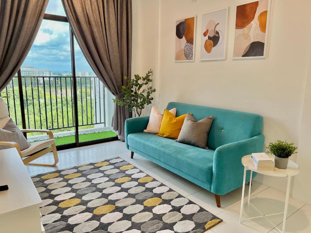 a living room with a blue couch and a window at PadiViu Family Suite at Imperio Professional Suite, Alor Setar in Alor Setar