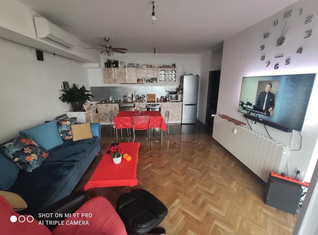 a living room with a couch and a tv and a kitchen at RiView in Rijeka