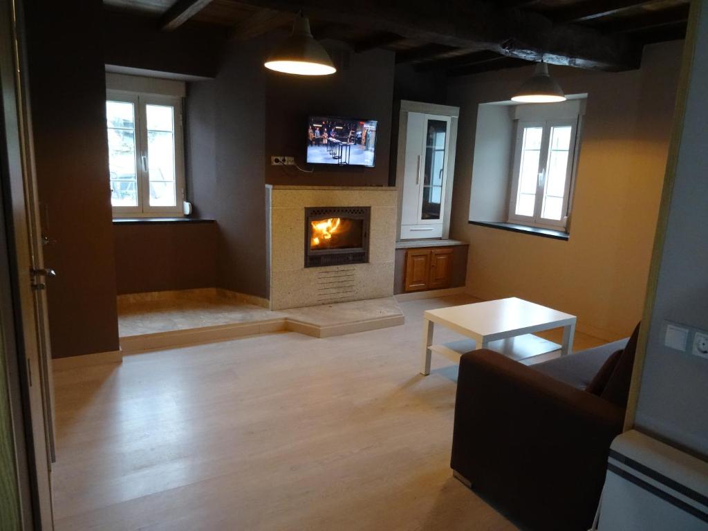 a living room with a fireplace and a couch at Casa Darivas in Trabada
