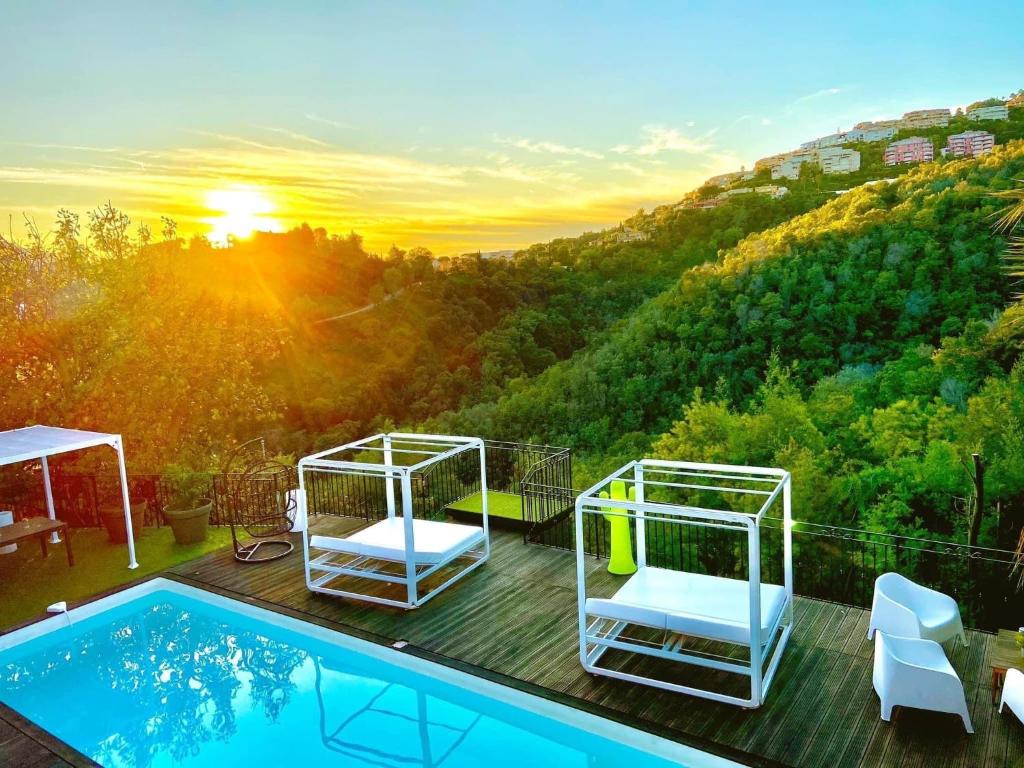 een villa met een zwembad en uitzicht op een berg bij VILLA COLINA in Mandelieu-la-Napoule