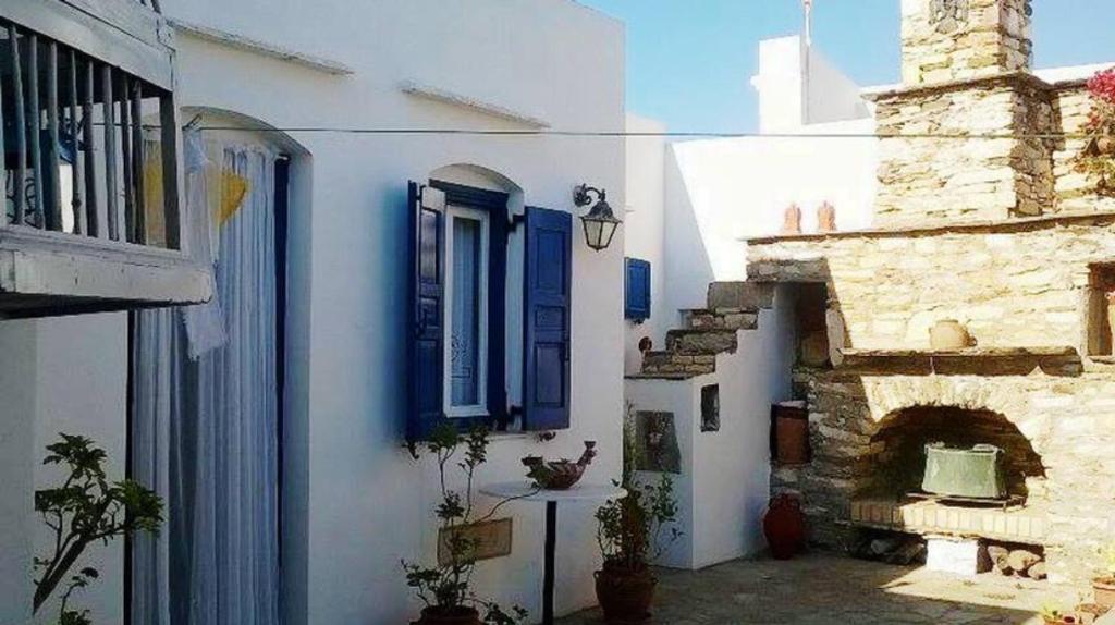 eine Gruppe weißer Gebäude mit blauen Fensterläden in der Unterkunft Apartment in the center of Artemonas, Sifnos in Artemonas