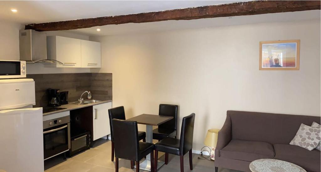 a kitchen and a living room with a table and a couch at Maison de vacances indépendante à Florensac, Hérault - 4 personnes in Florensac