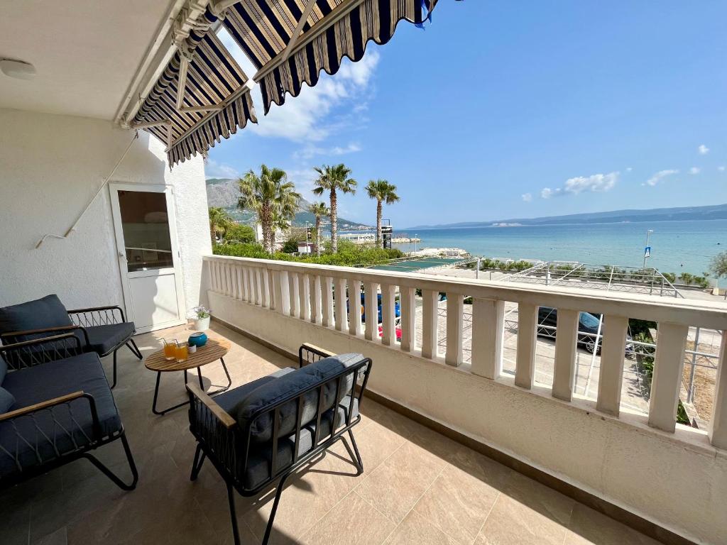 einen Balkon mit Stühlen und Meerblick in der Unterkunft Apartmani “Krešimir” in Omiš