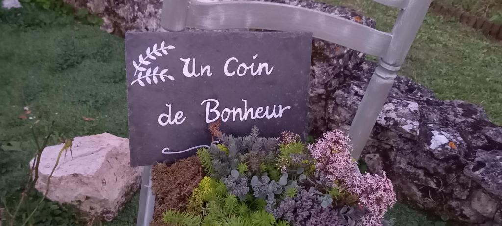 a sign in front of a garden with flowers at La Maison Josnes de Mady in Josnes