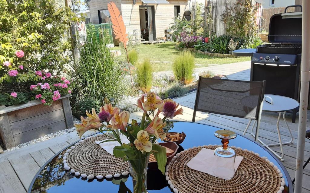 - une table avec un vase de fleurs sur la terrasse dans l'établissement Kerlobek l'id île, à Groix