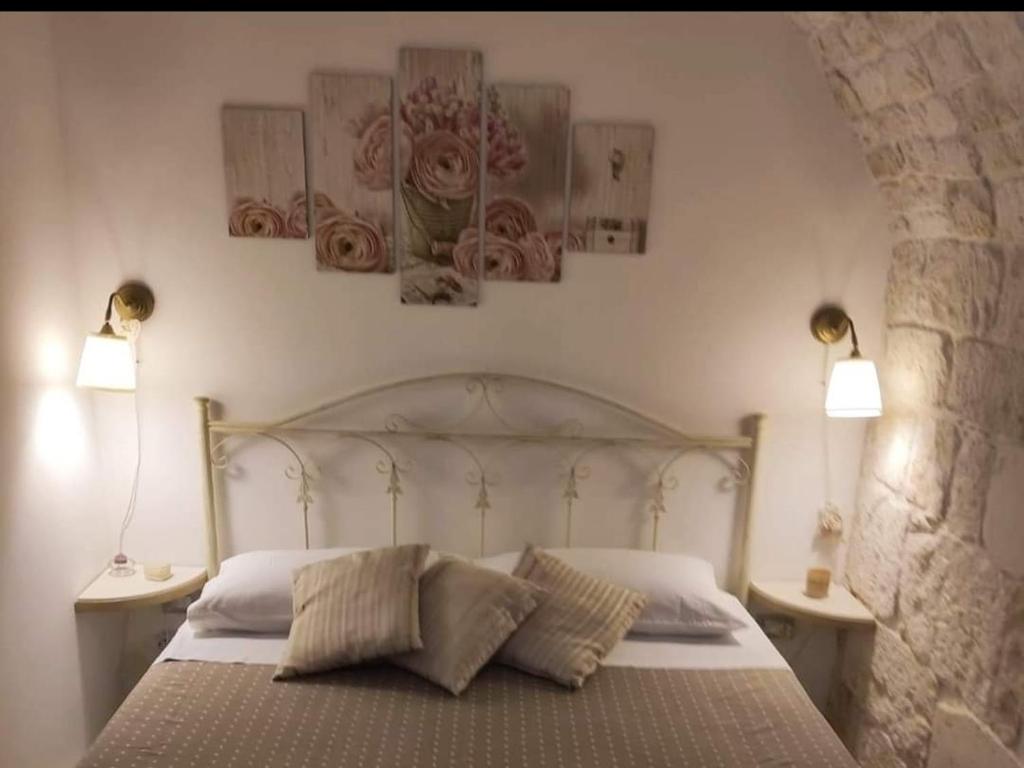 a bedroom with a bed with two lamps on the wall at Appartamento Bellini in Martina Franca