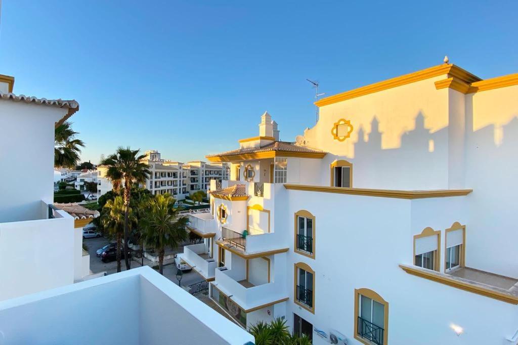 阿爾布費拉的住宿－Albufeira Central Apartment, 10 mins walk to beach，白色建筑的景色,上面有时钟