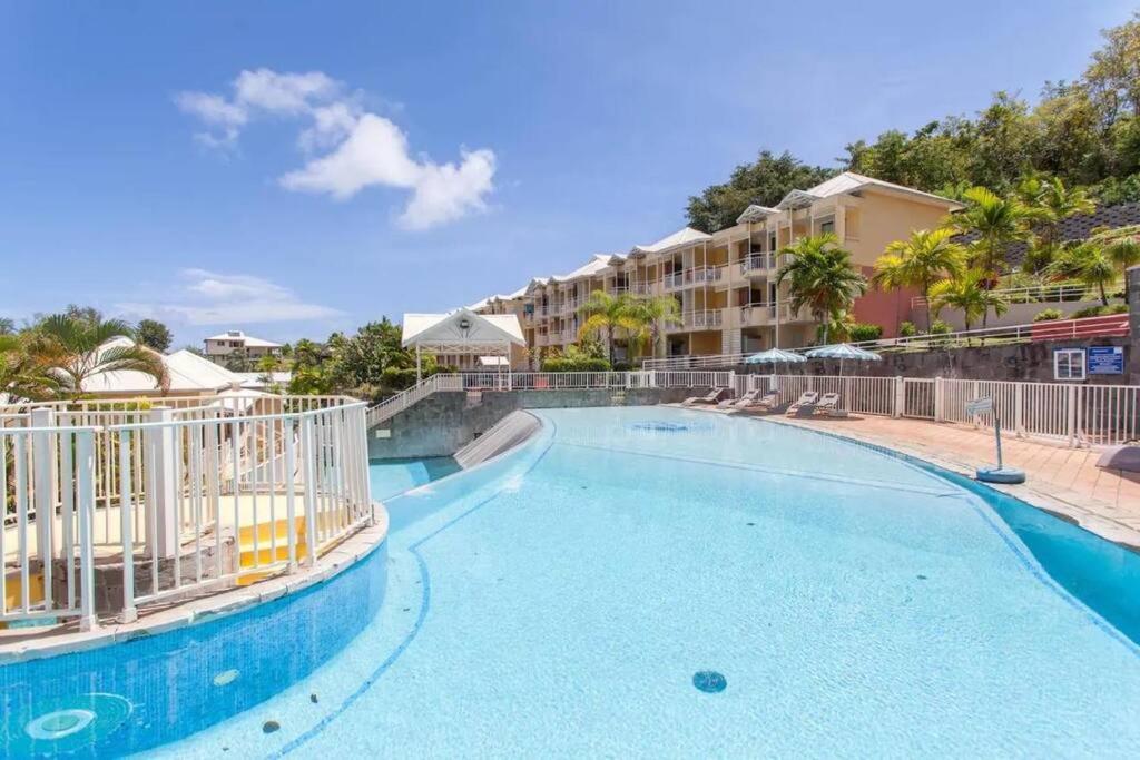 einen Pool in einem Resort mit Stühlen und einem Gebäude in der Unterkunft Appartement piscine et vue mer in Tartane