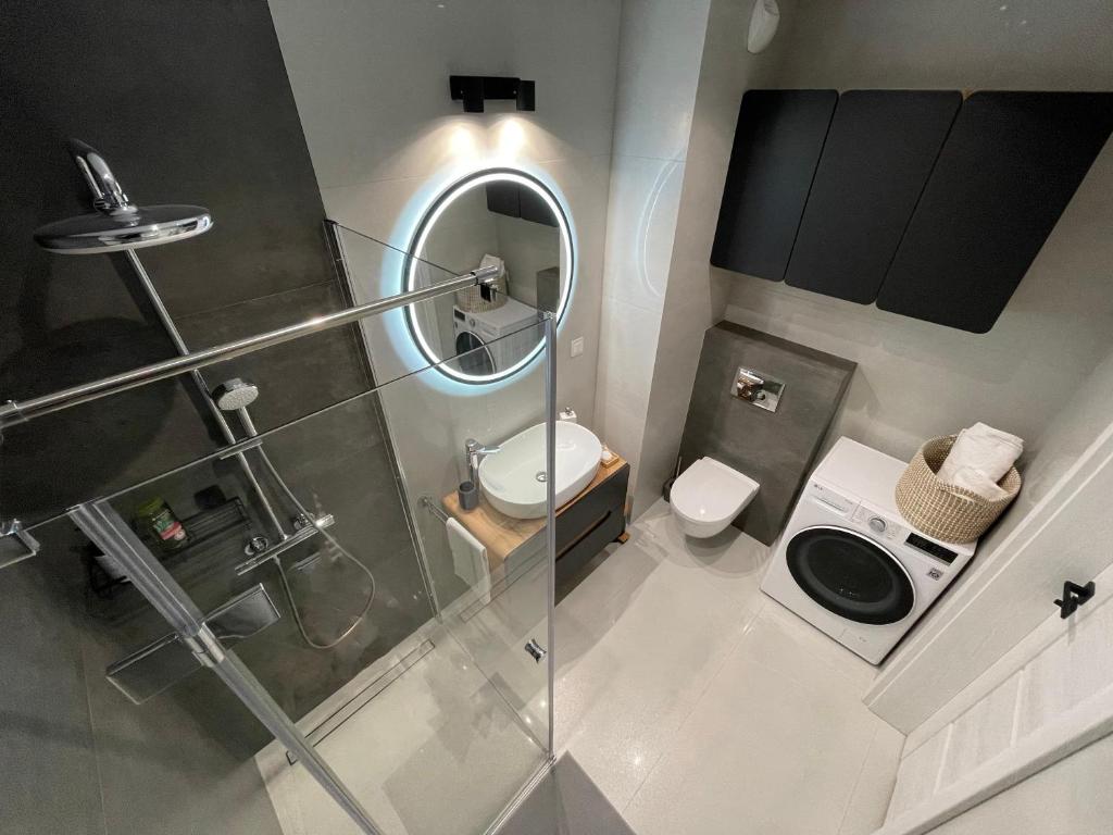 a small bathroom with a shower and a toilet at NEWPORT Industrial Apartment in Warsaw