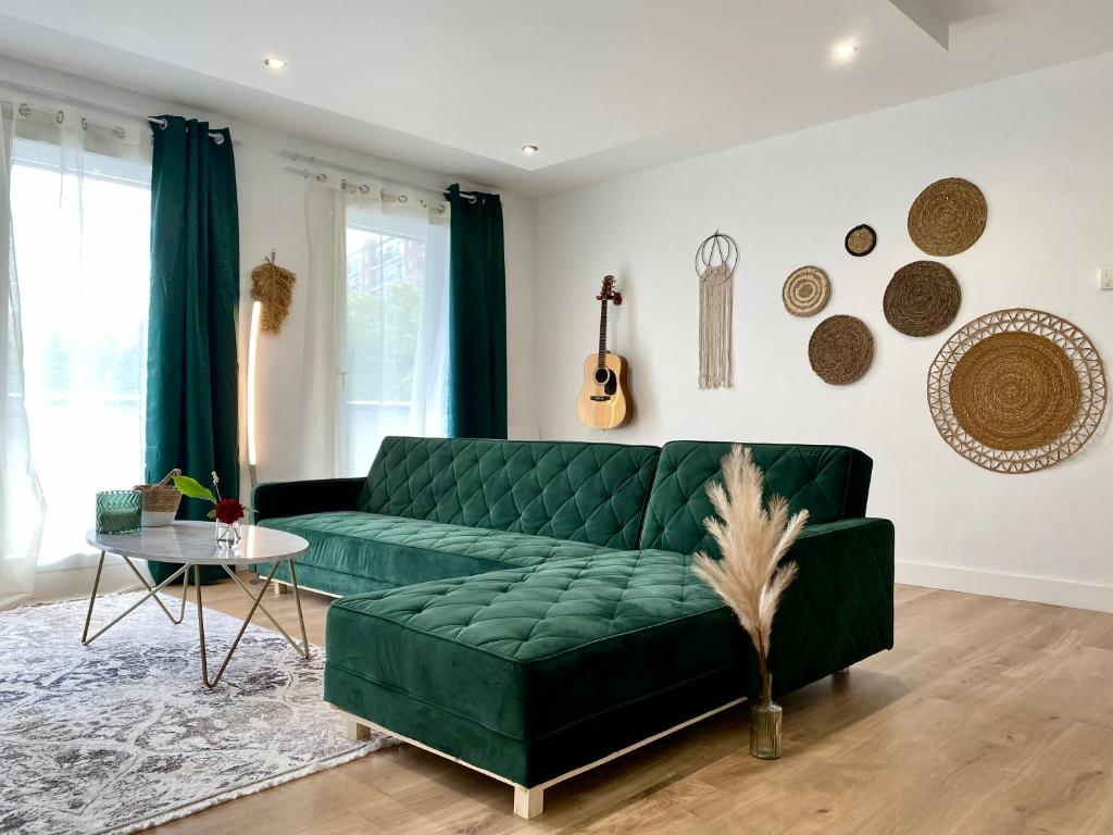 - un salon avec un canapé vert et une table dans l'établissement MM Greenhouse Appartement / Tourcoing - Lille, à Tourcoing