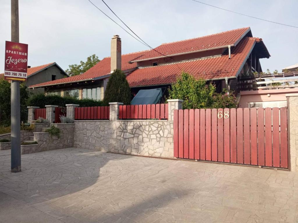 uma cerca vermelha em frente a uma casa em Jezero em Arandjelovac