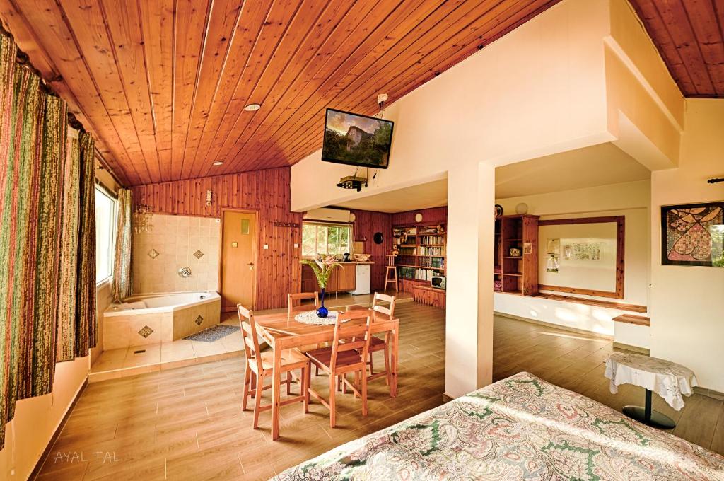 uma cozinha e sala de jantar com tecto em madeira em Bloom's Studio הסטודיו של בלום em Amirim